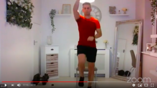 Photo of Josh Poole facing the camera and marching on the spot during the HIIT video