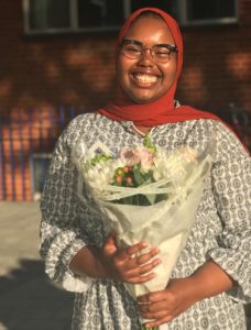 Safia Awal smiling and holding a bunch of flowers