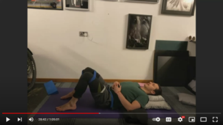 Jamie lying on a yoga mat on his back with his knees bent and hands resting on his stomach