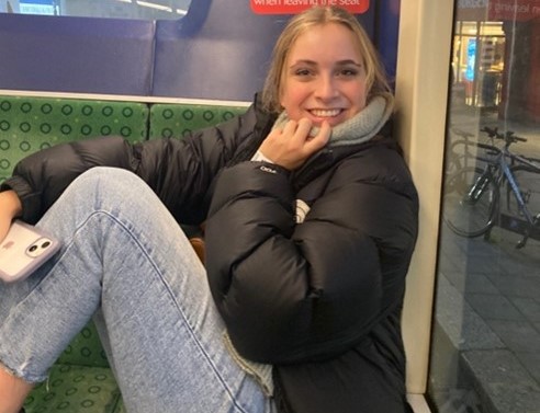 Emma sits smiling on a bus seat