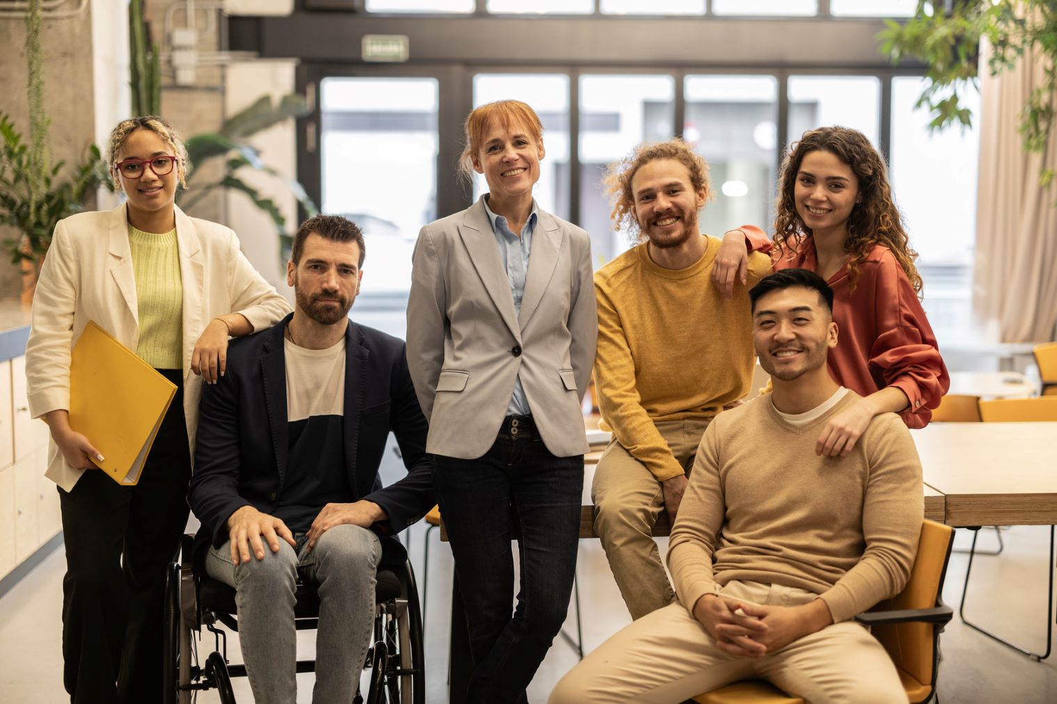 Group of four people standing, one sitting and one in a wheelchair